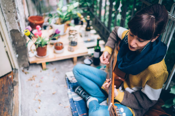 hippie woman playing the guitar at home - guitarist one person caucasian adult imagens e fotografias de stock