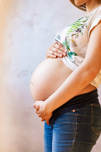 istock Pregnant woman embracing her belly 1189562873