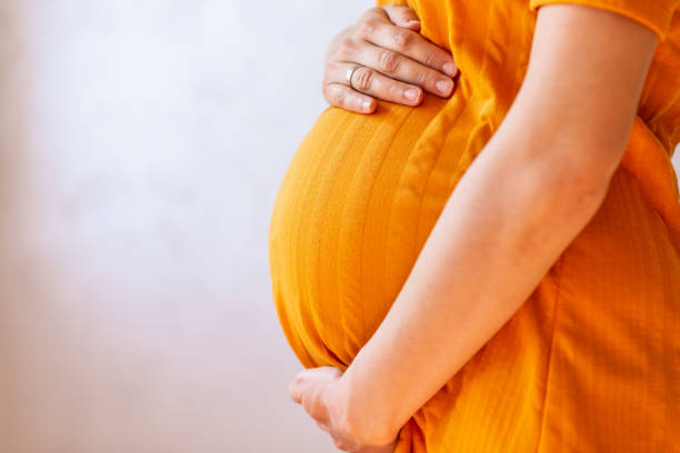 istock Pregnant woman embracing her belly 1189562894