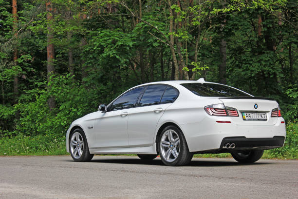 White BMW 520 TDI (F10) M Sport in the forest stock photo