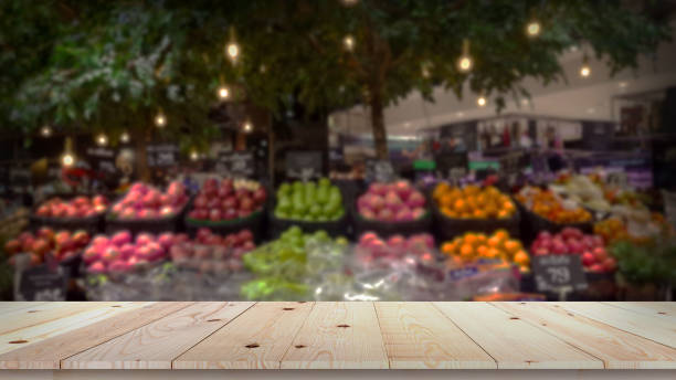 dessus vide de table en bois avec le fond brouillé brouillé de marché de fruit - fruits et légumes photos et images de collection