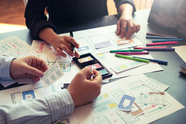istock Two designer creativity drawing a website outline and website ux app development on mobile phone. 1189567785
