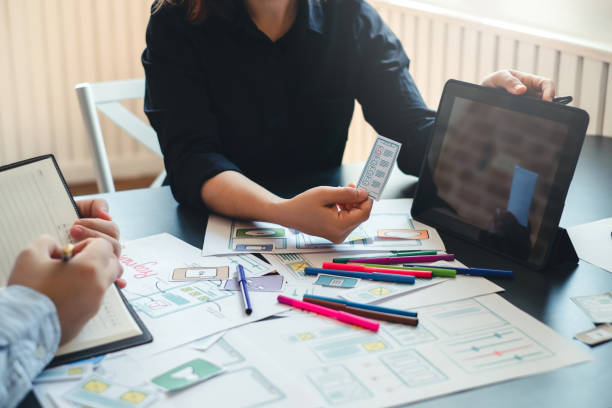 istock Two designer creativity drawing a website outline and website ux app development on mobile phone. 1189567806