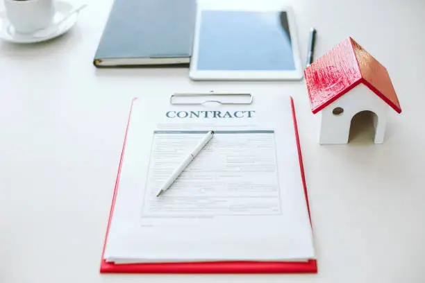 Photo of House and land purchase contract form on the brokerage desk of a real estate company.