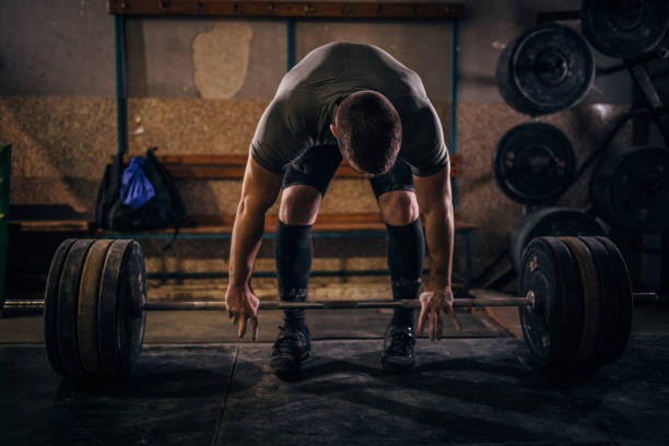 istock Man deadlifting barbell in gym 1189570305