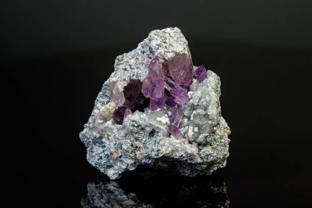 istock macro mineral amethyst stone in rock on a black background 1189570367
