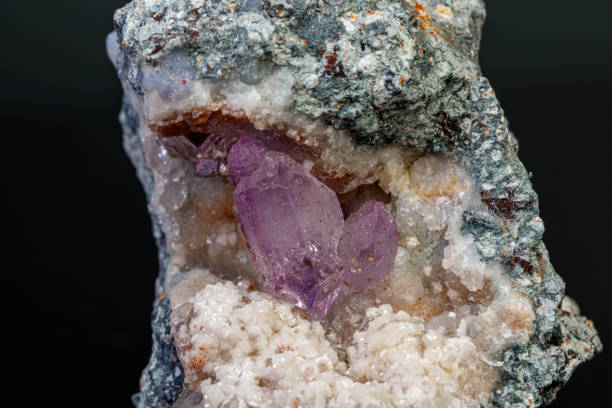 istock macro mineral amethyst stone in rock on a black background 1189570413