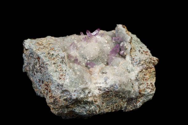 istock macro mineral amethyst stone in rock on a black background 1189570884