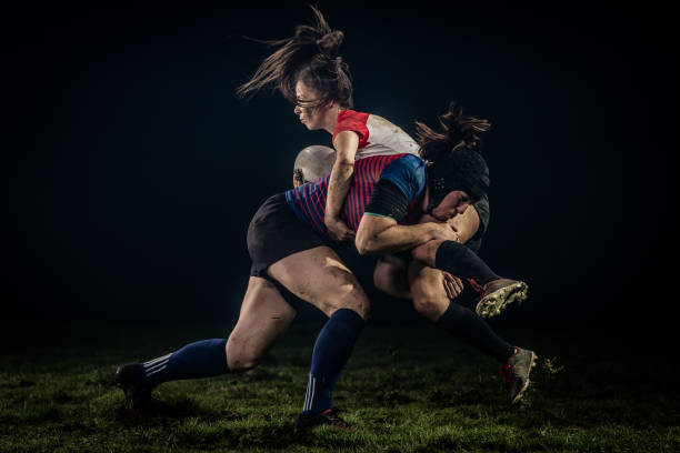 Rugby player tackling her opponent