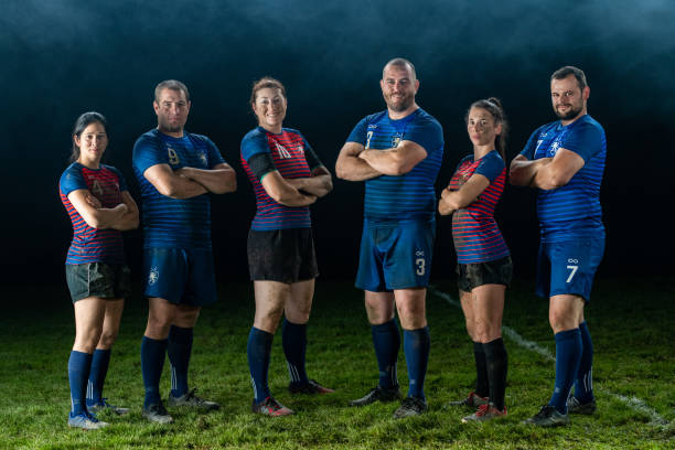 Rugby players standing on field Portrait of male and female rugby players with arms crossed standing on field. rugby team stock pictures, royalty-free photos & images