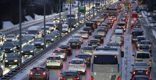 Traffic jam on highway during snow storm at dusk.