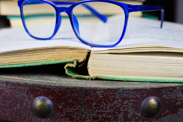 Open book on a table with autumn abstract background on the window for a cozy reading time at home