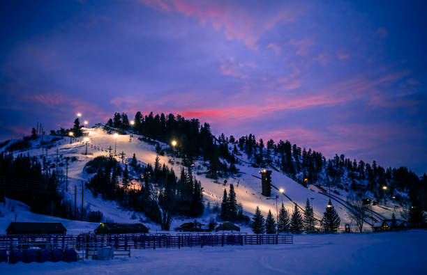 Colorado ski slope during blue hour in winter View of Colorado ski slope with running chairlift after sunset; blue hour in the mountains steamboat springs stock pictures, royalty-free photos & images