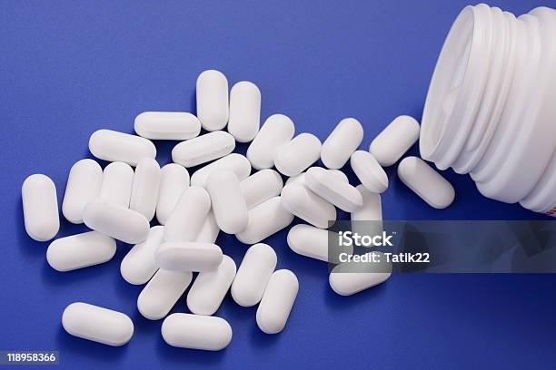 Spilled Tablets And Medicine Bottle Stock Photo - Download Image Now - Antibiotic, Blue, Bottle