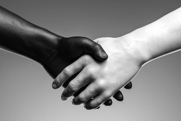 istock Close up of black and white hand handshake on light background . 3d rendering. reconciliation 1189585620