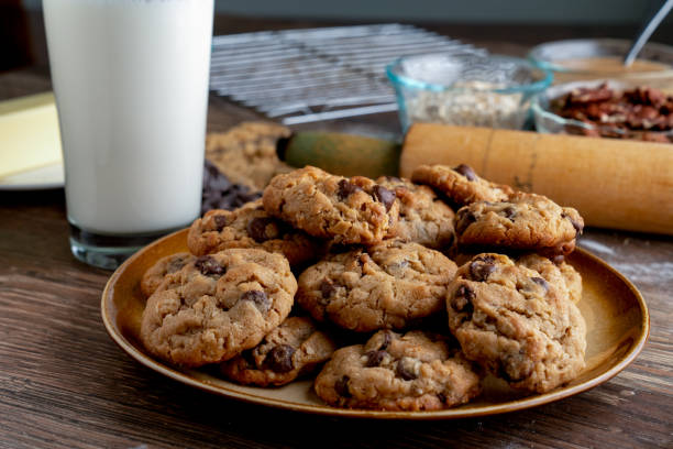 Delicious Baked Oatmeal, Peanut Butter, chocolate chip cookies, with a frosty glass of milk A frosty cold glass of milk, with a plate of peanut butter, oatmeal, dark and semi-sweet chocolate chip cookies chocolate chip cookie stock pictures, royalty-free photos & images