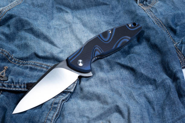 istock Pocket knife with a blue handle. Knife and jeans. 1189586759