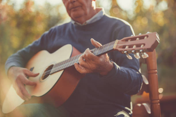 istock Guitar played by senior man outside 1189589426
