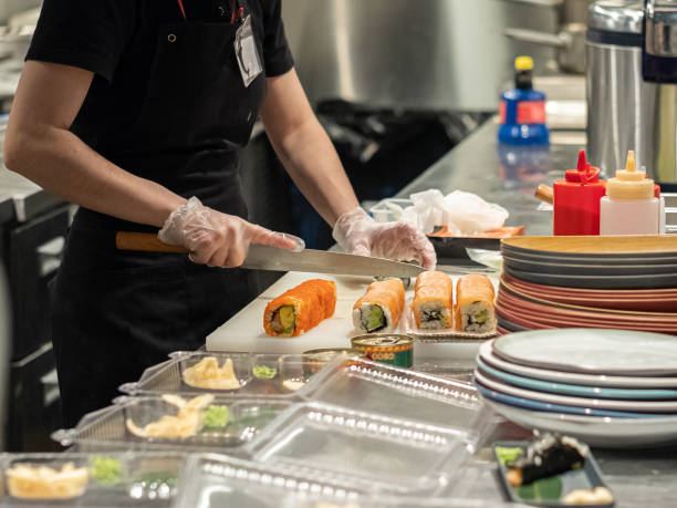 mãos em luvas de látex colocar para fora os ingredientes para rolos japoneses em recipientes descartáveis de plástico. comida japonesa tradicional feita de arroz e salmão. - asian cuisine horizontal spice restaurant - fotografias e filmes do acervo