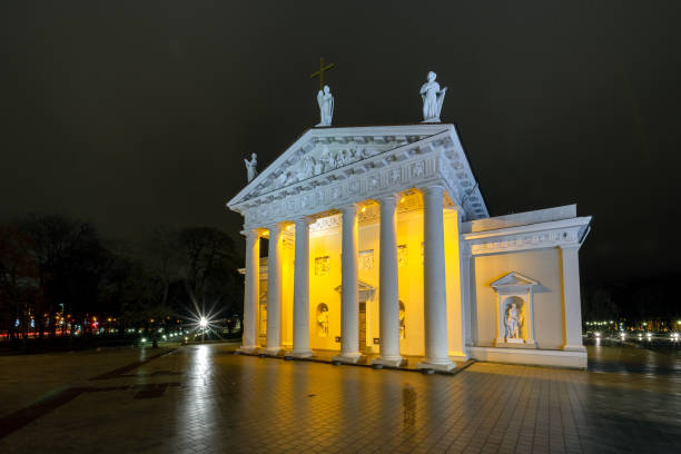 istock Illuminated Vilnius Cathedral and two human shapes late evening. Long time exposure. 1189594983