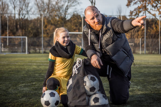 istock Soccer father coaching football daughter 1189595227