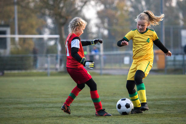 girls playing soccer during a football match - holanda futebol imagens e fotografias de stock