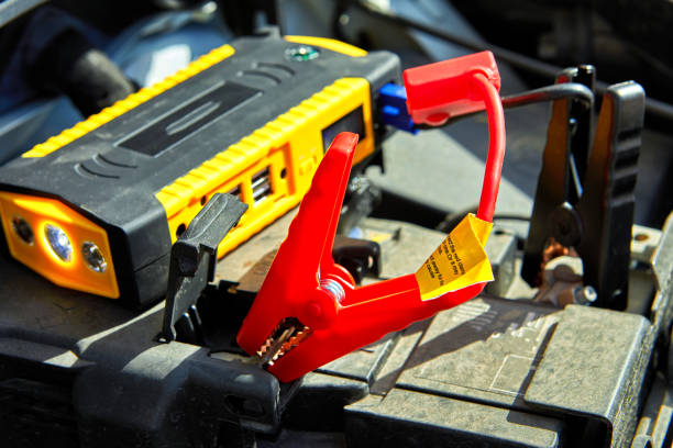 istock charging a car with electricity through cables from a compact battery 1189598089