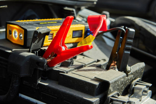 istock charging a car with electricity through cables from a compact battery 1189598722