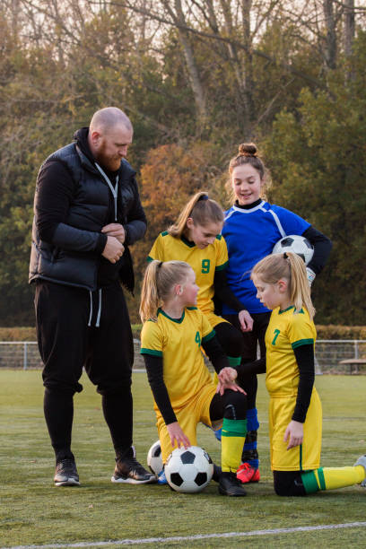 istock Soccer father coaching football daughter's team during a training session 1189599953