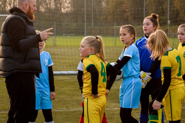 istock Soccer father coaching football daughter's team during a training session 1189599957