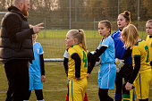Soccer father coaching football daughter's team during a training session