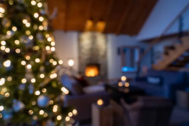 Defocused Christmas decor in a living room with a fireplace in background.