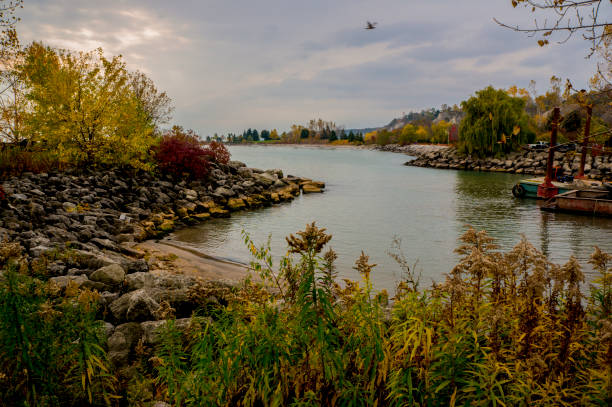 Rocky Shoreline Pier In A Park At The Edge Of A Lake Or Ocean In Autumn With The Trees Changing Color stock photo