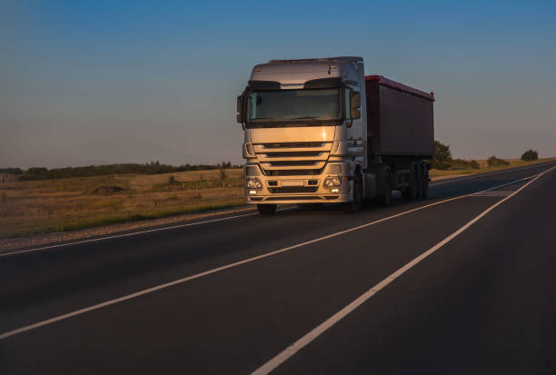 istock truck goes on highway on sunset 1189607258