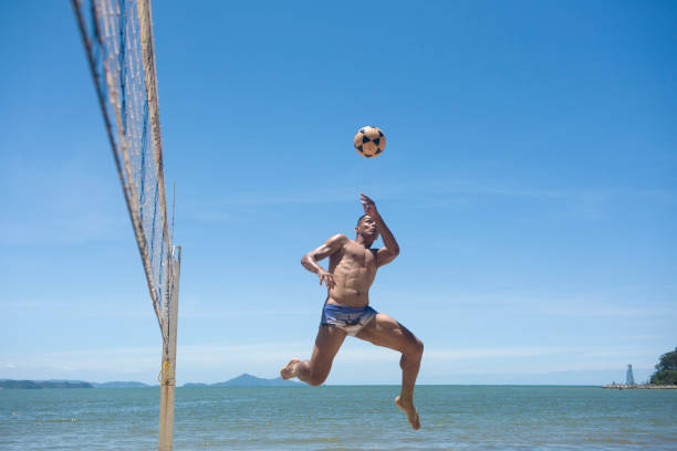 hombre afro brasileño juega voleibol de pie en balneário camboriu - beach football fotografías e imágenes de stock