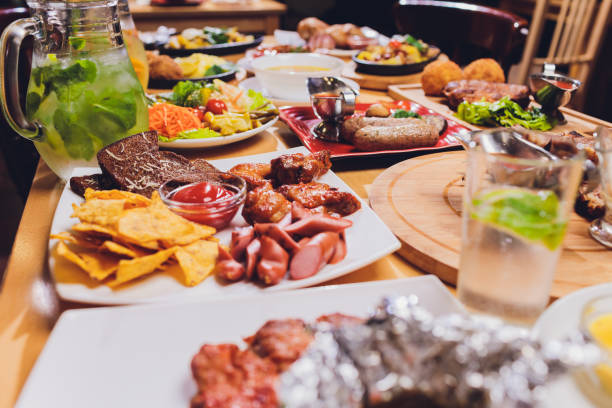 istock Dinner table with meat grill, roast new potatoes, vegetables, salads, sauces, snacks and lemonade, top view. 1189616892