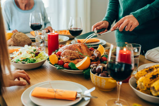 istock Unrecognizable person cutting roasted turkey during holiday dinner at dining table. 1189618247