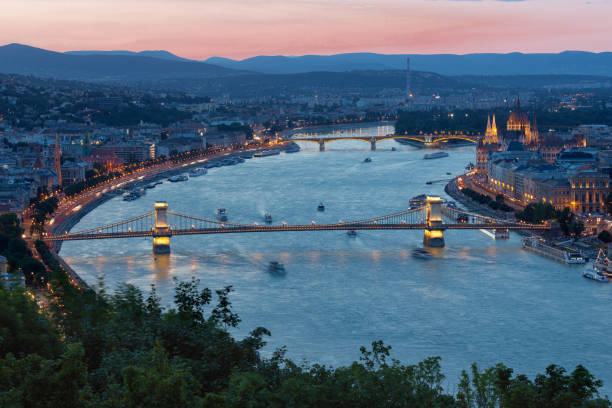 coucher du soleil budapest le long du danube avec le pont de chaîne et le bâtiment de parlement - budapest parliament building chain bridge night photos et images de collection