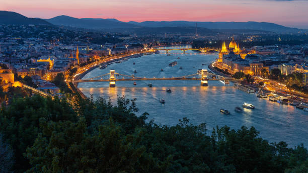 coucher du soleil budapest le long du danube avec le pont de chaîne et le bâtiment de parlement - budapest parliament building chain bridge night photos et images de collection