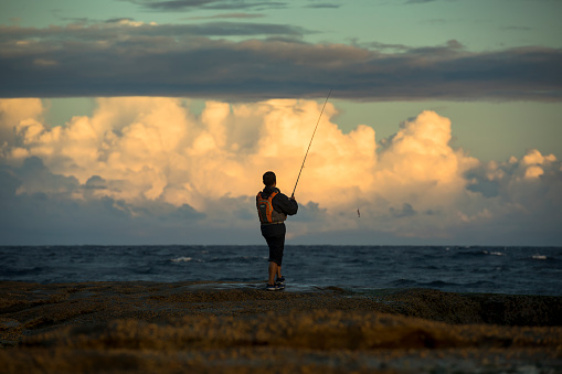 Sydney, Australia - March 01 2019: Tow fishermen fishing at sunset at Bondi Beach, Sydney, Australia