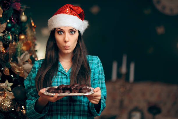 femme retenant un plateau des biscuits attendant le père noel - cookie women eating beautiful photos et images de collection