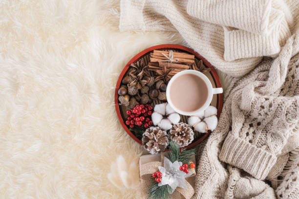 istock Autumn or winter composition. Gift box Coffee cup, cinnamon sticks, anise stars, beige sweater with knitted blanket on cream color gray fluffy background. Flat lay top view copy space. 1189636588
