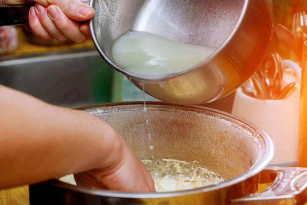 istock Pouring water into bowl with flour in a bakery on table 1189642113