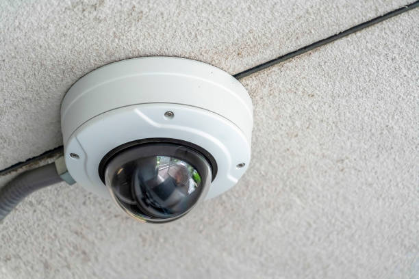 istock Close up of a cctv dome video security camera installed outside a building 1189642910
