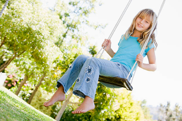 istock Young girl sitting on swing smiling 118964567