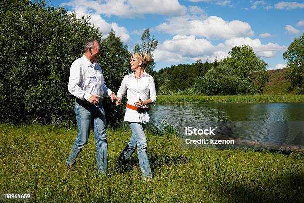 Senior Couple Running On A Meadow Stock Photo - Download Image Now - Active Lifestyle, Active Seniors, Adult