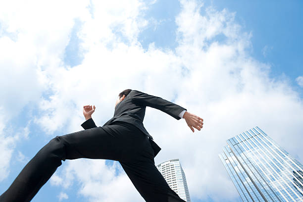 istock Low angle photo of man in suit running under blue sky 118964759