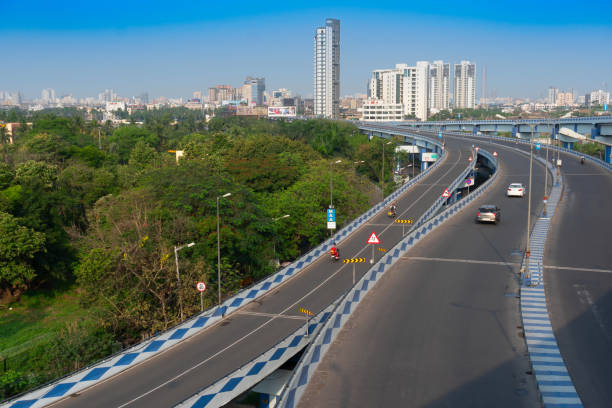 View of a bicycle lane and bridge in the foreground, and elevated road over Periferico Boulevard passing though Chapultepec Park in downtown Mexico City, the ramp and elevated road with solar panel lamps