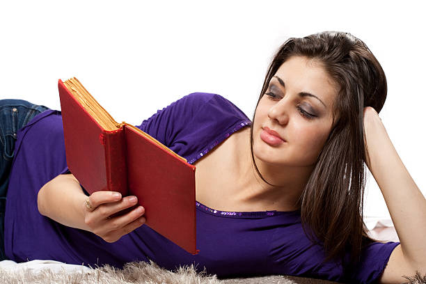 Retro-styled toned portrait of young attractive woman sitting and holding the book.