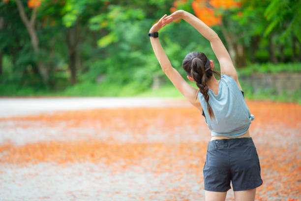 istock Back view of runner woman doing stretching and warming up her body before running. 1189667483